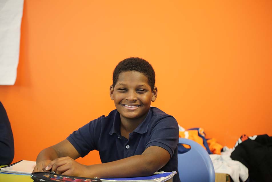 student in classroom smiling at camera