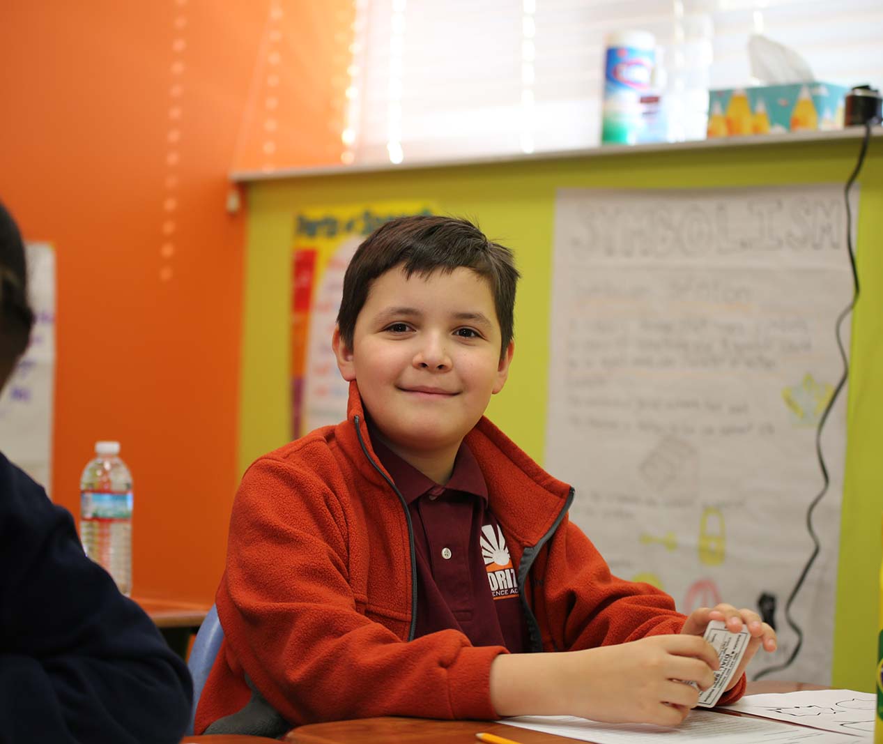 Student working on a notebook in a classroom.